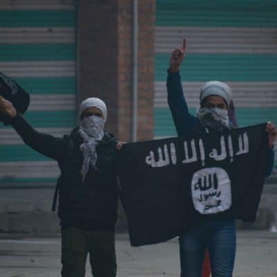 Kashmiri masked protester waving flags during clashes in Nowhattah Srinagar after Friday prayers on 21st December 2018