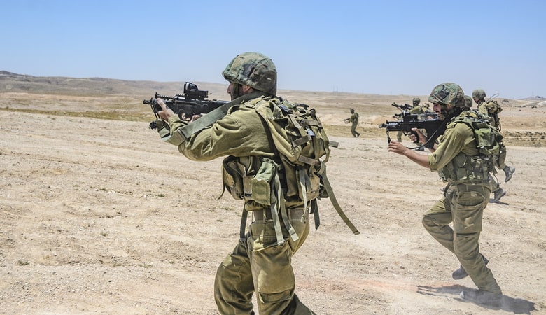 Israeli army combat soldiers firing while charging on terror targets